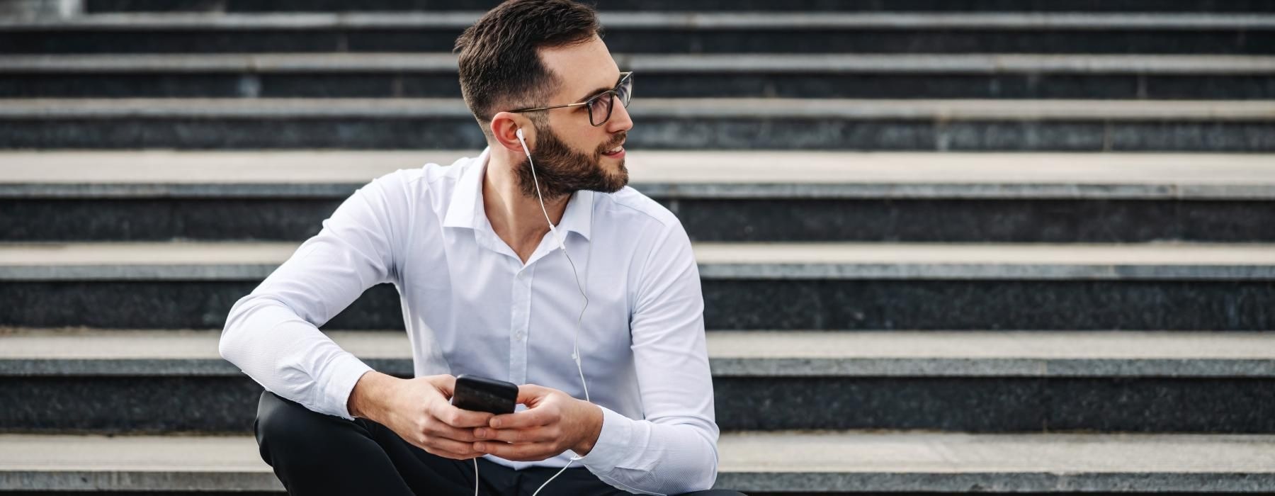 a person sitting on stairs looking at the phone